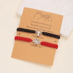 Detail of handmade spider and web charms on woven bracelets with emotional card message