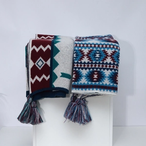 Ethnic bohemian style knit shawls with fringes in burgundy and blue displayed on white pedestals