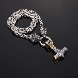 Detail of Viking Thor Hammer pendant with wolf heads on Byzantine chain over black background