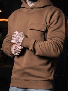 Close-up of brown hoodie featuring drop shoulder design and a rectangular front flap pocket