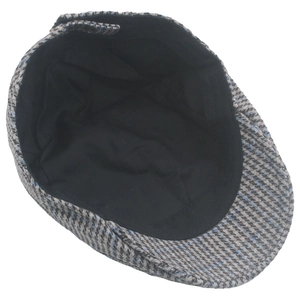 Detail of wool tweed houndstooth flat cap featuring black fabric lining and reinforced edge