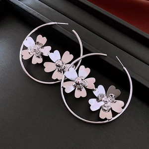 Macro shot of silver metal hoop earrings with elegant 3D heart-shaped floral accents
