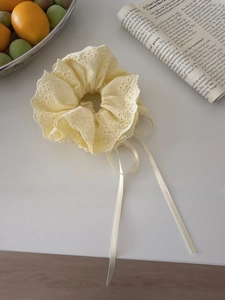 Close-up of beige heavy embroidery lace scrunchie with ribbons in French retro style