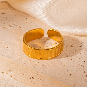 Macro detail of 18K gold-plated open ring with vertical striped texture on stone base