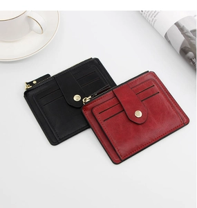 Macro detail of leather texture on red and black multi-slot wallets with metal snap button