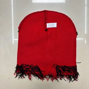 Detail of red camouflage beanie showing 100% acrylic material tag and fringe edges