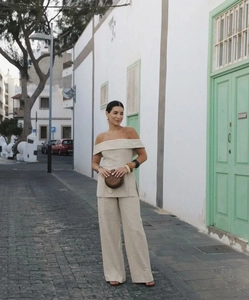 Detail of beige off-shoulder top and high-waist wide-leg trousers in linen texture