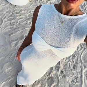Detailed close-up of white knitted texture and hollow-out pattern on a beach maxi dress