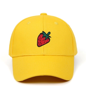 Detailed view of yellow baseball cap with red strawberry embroidery and six-panel crown