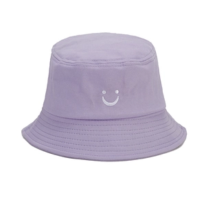 Close-up of light purple cotton bucket hat featuring white embroidered smiley face and stitched brim