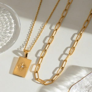 Double-layered gold stainless steel necklace with starburst engraved square pendant