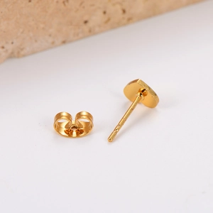 Boucles d'oreilles cœur minimalistes en acier inoxydable doré sur un support en pierre