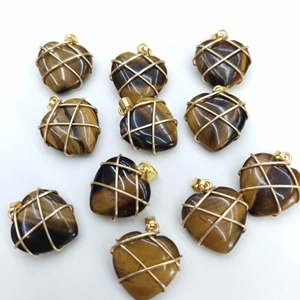 Pink crystal heart pendants with gold wire wrapping on clean white background