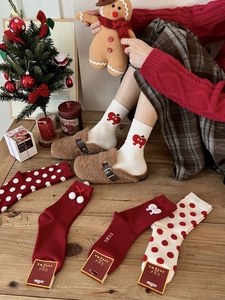 Detailed knit texture of red Christmas socks with holiday cherry and apple embroidery