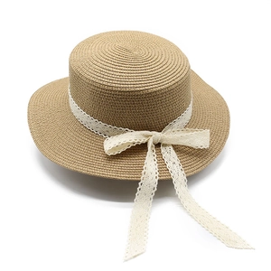 Detailed view of boater hat featuring elegant cream lace ribbon and a bow decoration