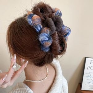 Detail view of large mohair bow hair claw clip in vintage blue and orange textured fabric