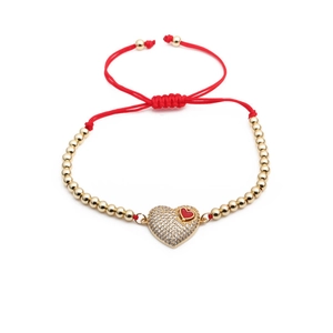 Adjustable red cord bracelet with gold beads and a sparkling zircon heart charm pendant
