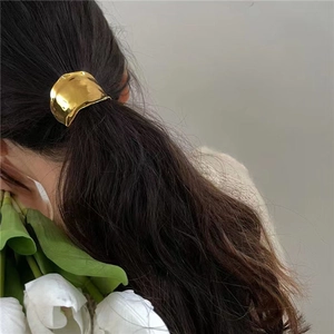 Minimalist golden irregular metal hair hook for low ponytail styling on model