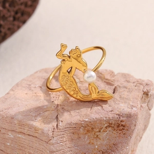Close-up of golden mermaid ring with pearl on pink stone base showing fine craftsmanship
