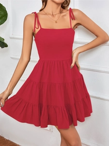 Red sleeveless mini sun dress featuring tie-up straps and tiered layered skirt design