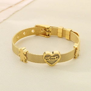 Detail of golden mesh bracelet with heart mama charm and boy girl pendants on beige desk