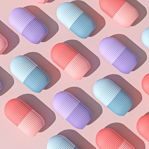 Detailed view of colorful capsule-shaped silicone face ice rollers in purple, pink and blue