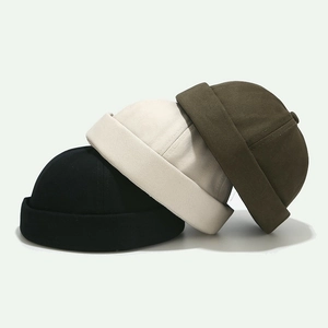 Three minimalist cotton docker hats in black, beige, and army green set on plain background