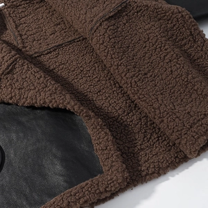 Close-up of brown faux shearling fabric stitched with black leather material detail