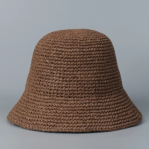 Close-up of the handcrafted woven texture and brim detail of this brown straw sun hat