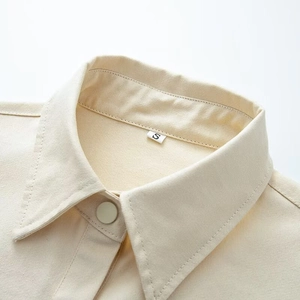 Minimalist cream twill chore jacket with lapel collar and button closure detail
