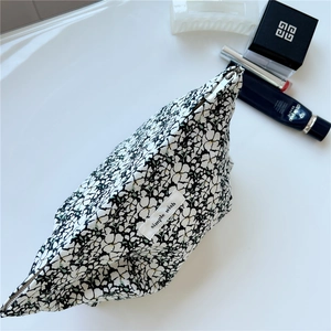 Close-up of floral cotton cosmetic bag with simple wish label and zipper detail