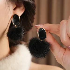 Elegant gold-edged black resin oval earrings with fluffy faux fur pompoms for women