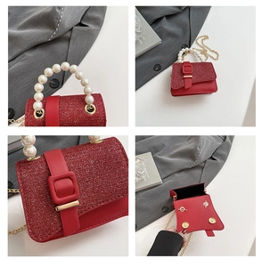 Detail of red sequin handbag with pearl bead handle and gold metal chain strap