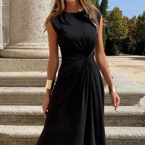 Detail of elegant black sleeveless dress with waist pleats and cinched waist design