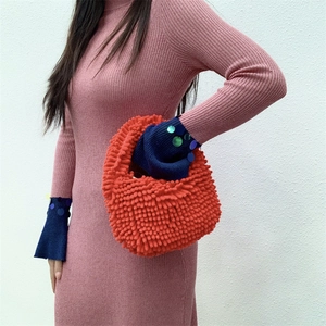 Close-up of fluffy orange chenille handbag with soft plush texture and integrated handle