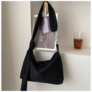Minimalist black canvas tote bag with knot detail and metal chain in lifestyle setting