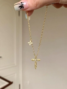 Detailed close-up of 24K gold plated cross pendant necklace with zircon stone inlay