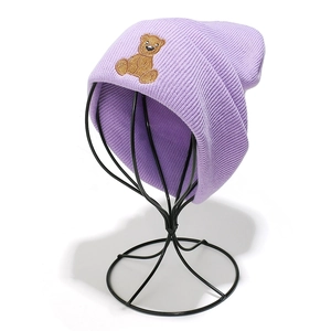Detail showing lavender ribbed knit beanie with a cute brown bear embroidery