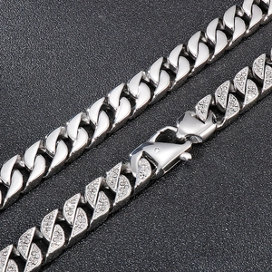Silver iced out Cuban chain necklace with polished links and lobster clasp on black texture