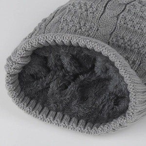 Close-up of winter knit hat showing thick gray fleece lining and cable knit texture