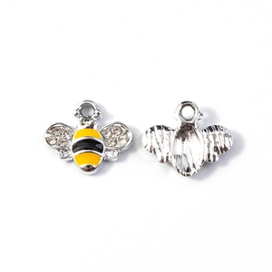 Macro detail of bee pendant showing silver body with yellow enamel and crystal wings