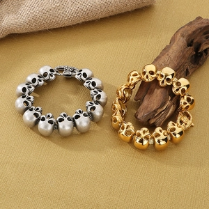 Detail of vintage skull bracelets in gold and silver finish on a rustic wooden background