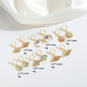 Set of six vintage gold devil's eye earrings with pearls and blue stones on white silk
