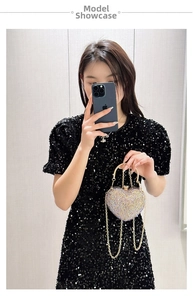 Detail of heart-shaped evening bag with champagne crystals and gold ring handle