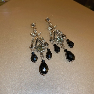 Detailed macro view of vintage silver earrings with black teardrop beads and crystals