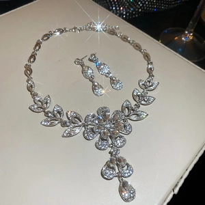 Detailed view of silver flower necklace and teardrop earrings set with sparkling crystals