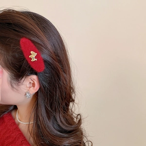 Close-up of red flocked hair clip with golden pony metal ornament worn on side hair