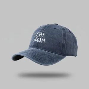 Detail of CAT MOM embroidery on a dark blue washed cotton denim baseball cap