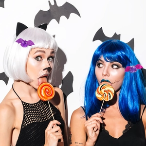 Halloween purple glitter bat wing hair clips shown on models in a festive party setting