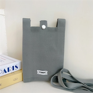 Detailed close-up of gray knitted mobile phone bag with vertical ribbed texture and metal snap